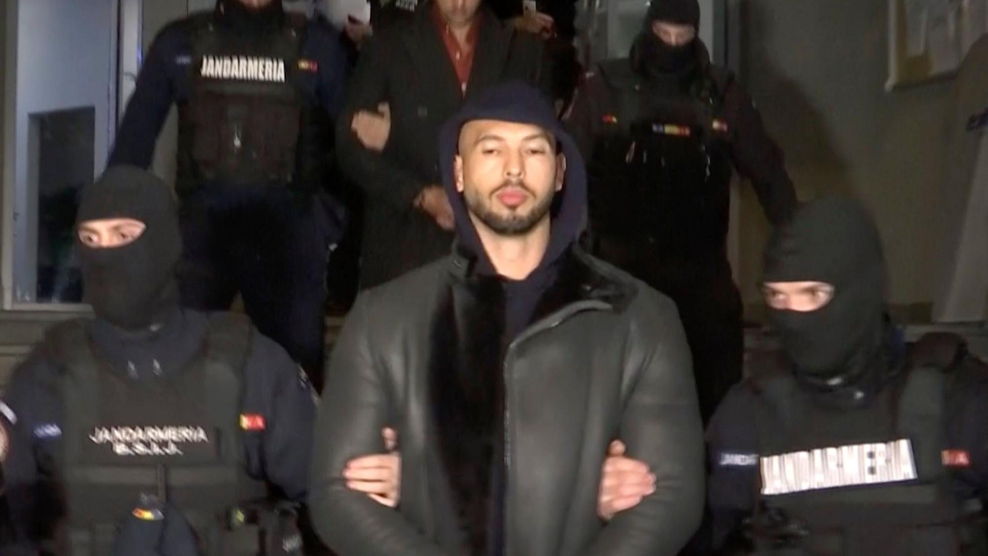 Dieses Videostandbild zeigt Andrew Tate (M) bei seiner Festnahme durch die rumänische Polizei im Dezember 2022.