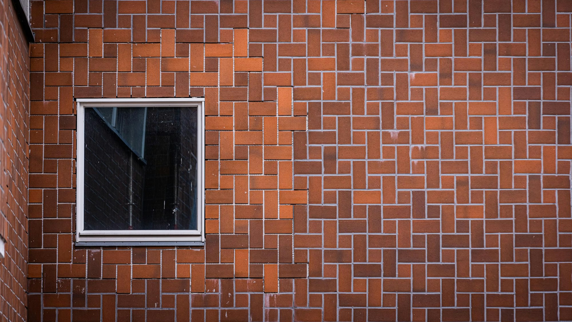 An der Fassade des Opernbaus ist zu sehen, dass die Fugen teilweise ganz fehlen, beschädigt sind, oder ganze Platten fehlen.