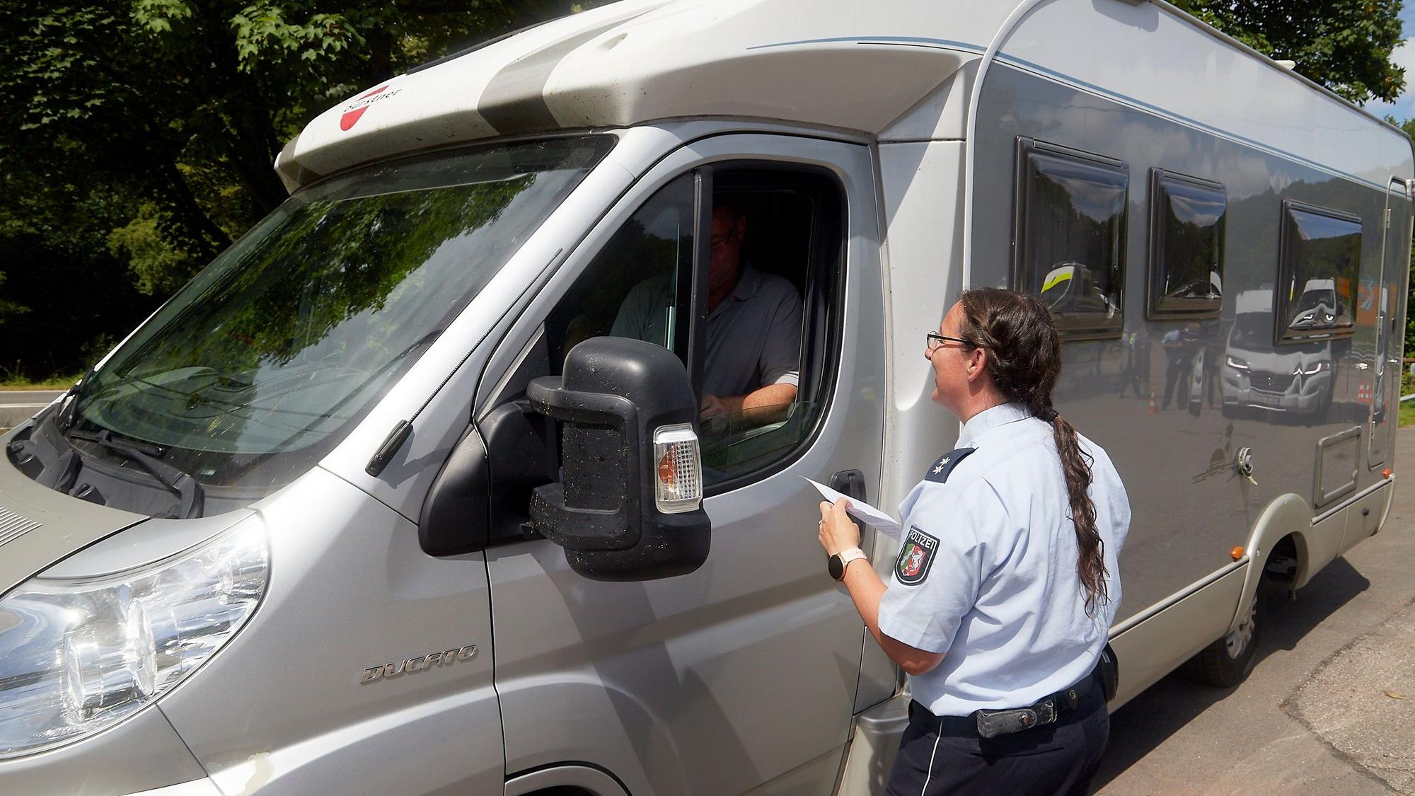 Das Bild zeigt eine Polizistin an einem Wohnmobil.