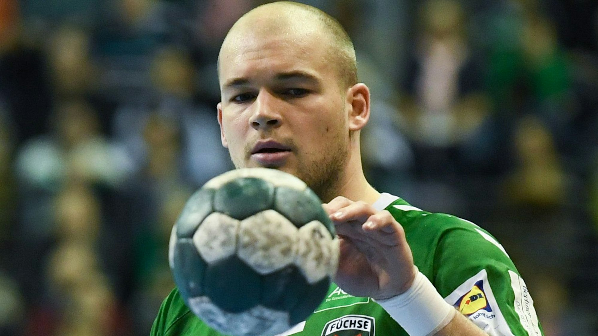 Füchse-Spieler Paul Drux fixiert und berührt einen Handball.