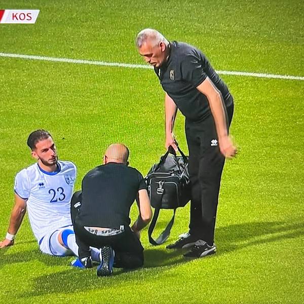 Kosovos Nationalspieler Leart Paqarada sitzt mit einer Knöchelverletzung auf dem Rasen und muss ausgewechselt werden.