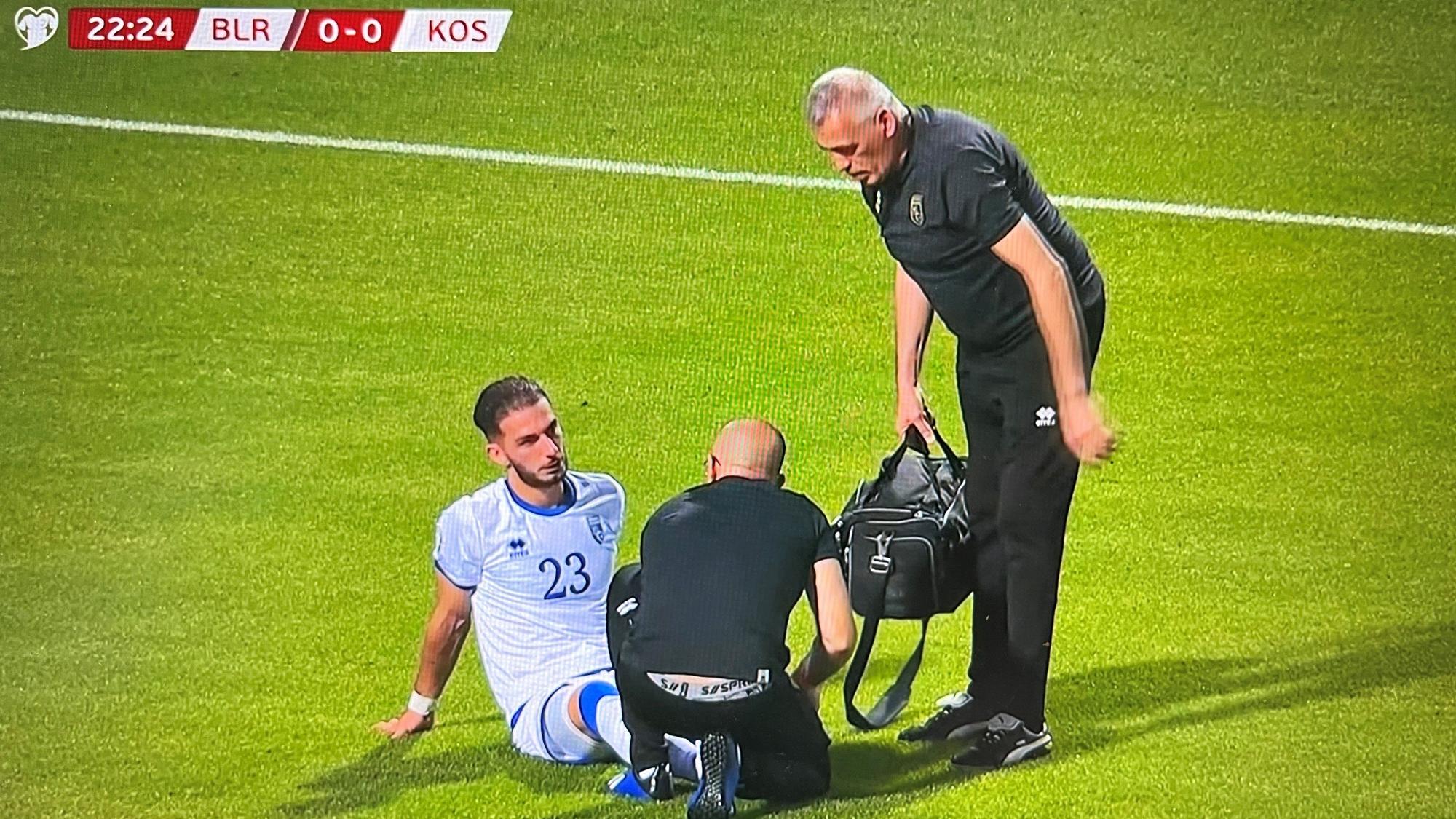 Kosovos Nationalspieler Leart Paqarada sitzt mit einer Knöchelverletzung auf dem Rasen und muss ausgewechselt werden.