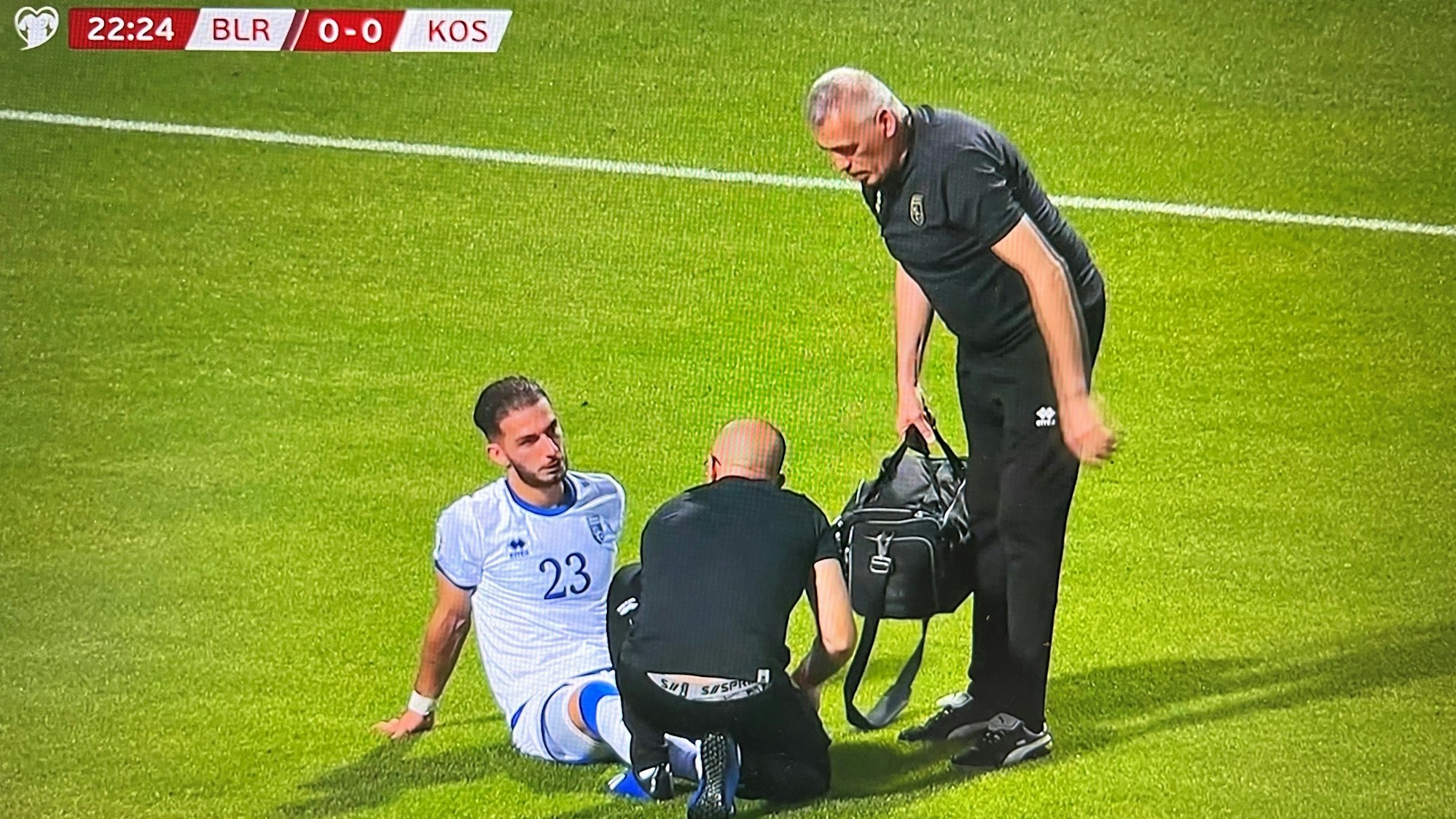 Kosovos Nationalspieler Leart Paqarada sitzt mit einer Knöchelverletzung auf dem Rasen und muss ausgewechselt werden.