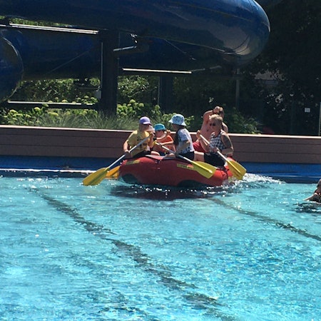 Ein mit Personen besetztes Schlauchboot im Swimming Pool.