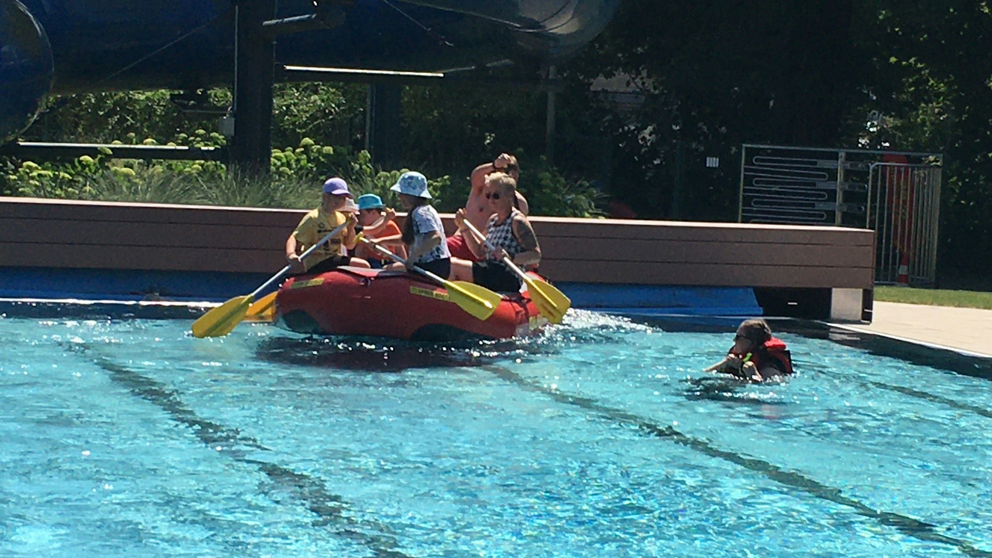 Ein mit Personen besetztes Schlauchboot im Swimming Pool.