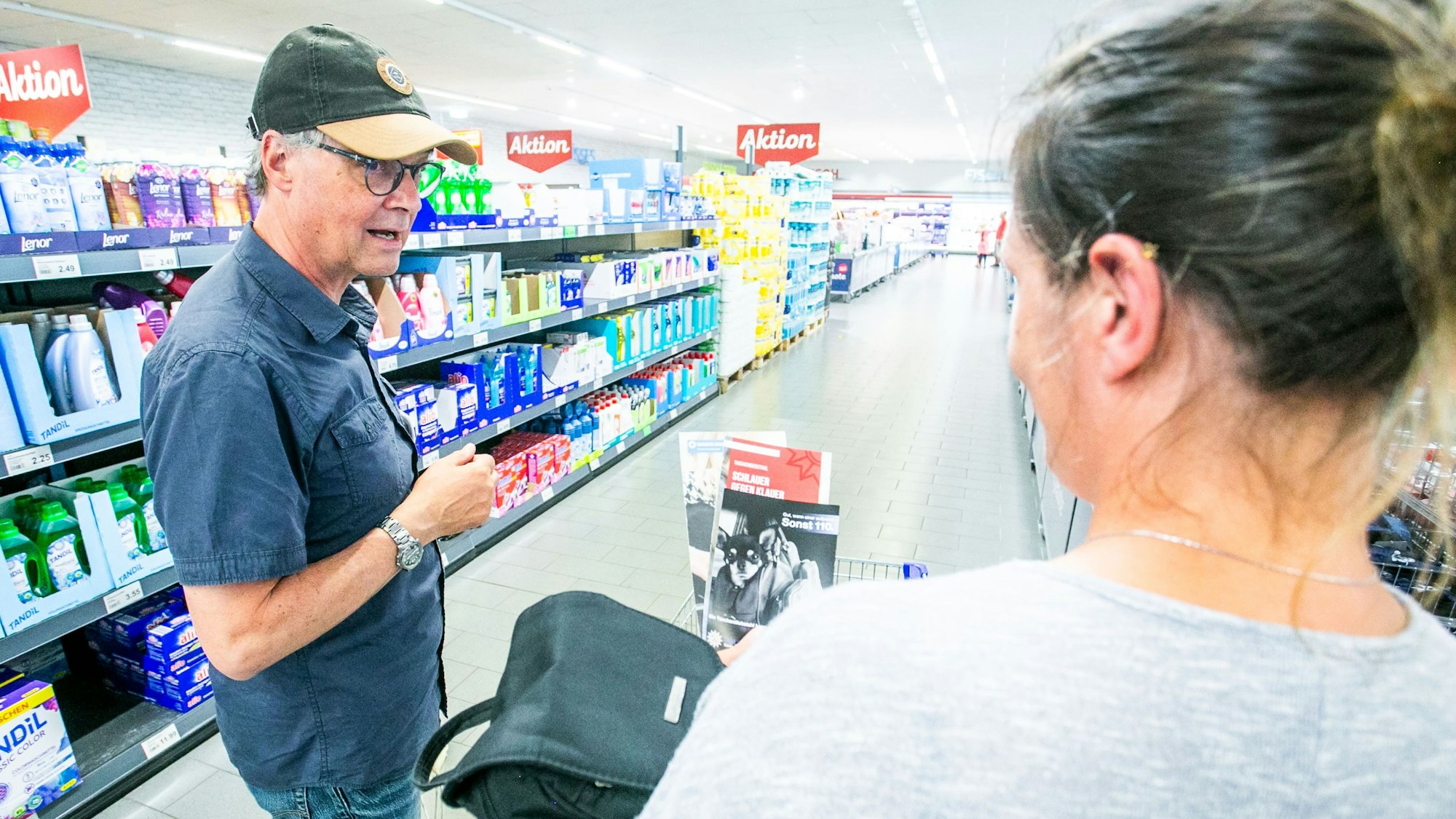Ein Mann spricht in einem Supermarkt mit einer Frau.