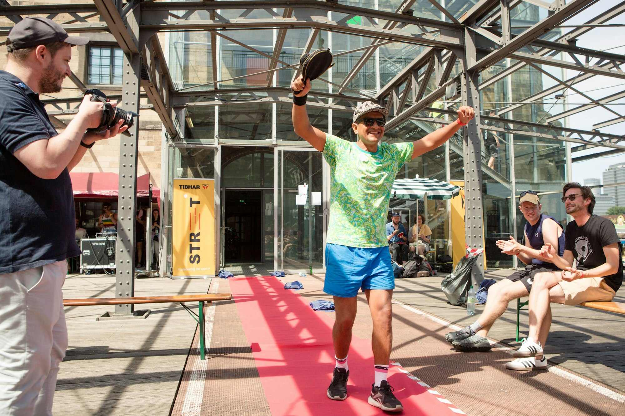Ein Tischtennisspieler läuft in Siegerpose auf der Terrasse des Sportmuseums in Köln.