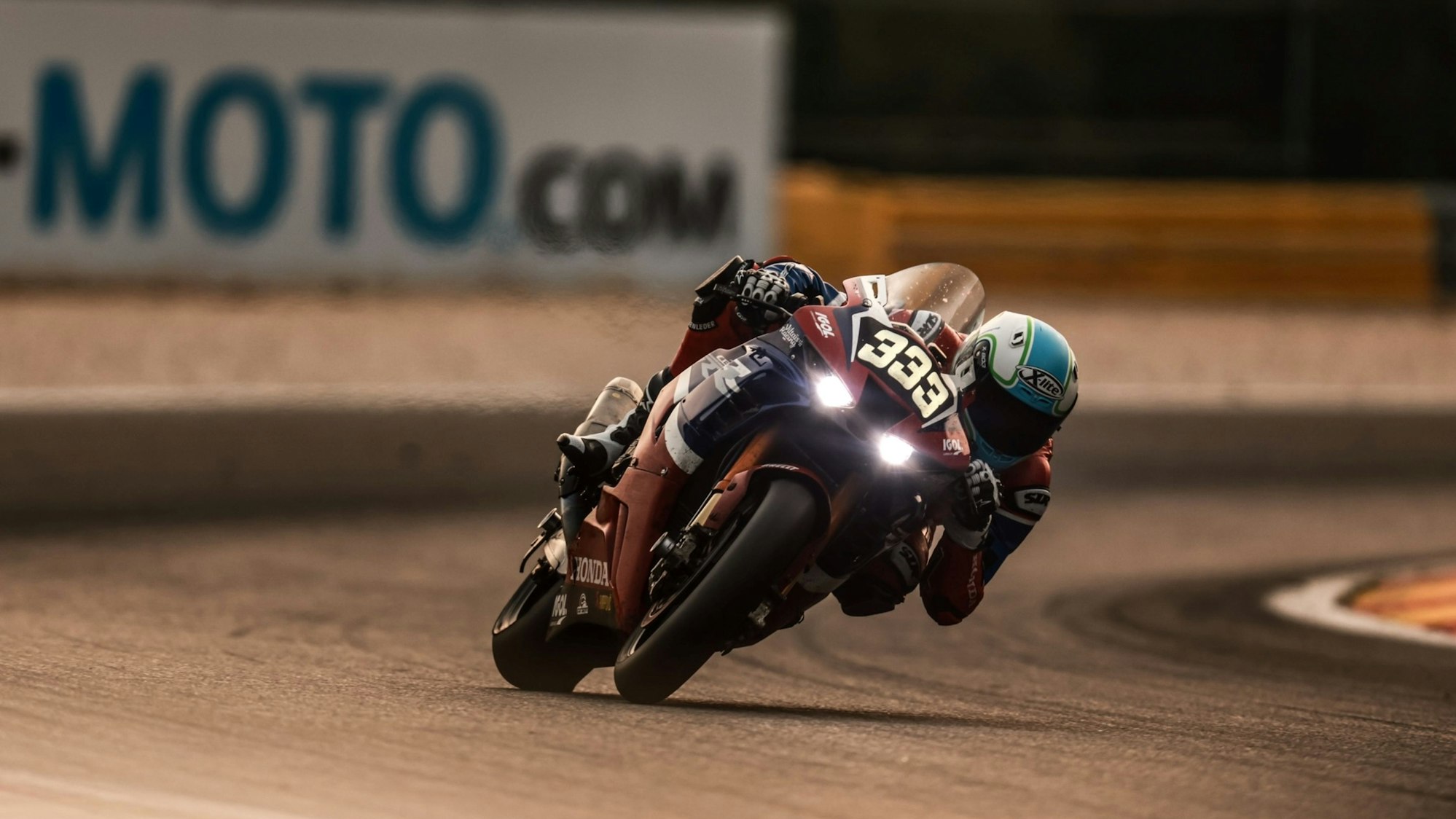 Im Bild ist ein Motorrad-Rennfahrer in der Dämmerung.