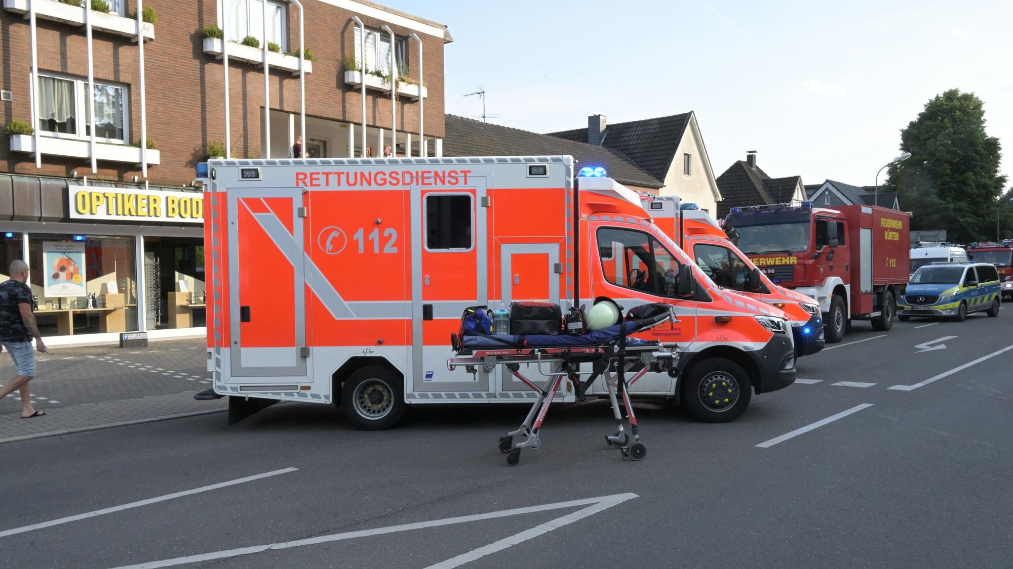 Rettungswagen und Feuerwehrfahrzeuge stehen auf der Wipperfürther Straße im gesperrten Ortskern von Kürten.