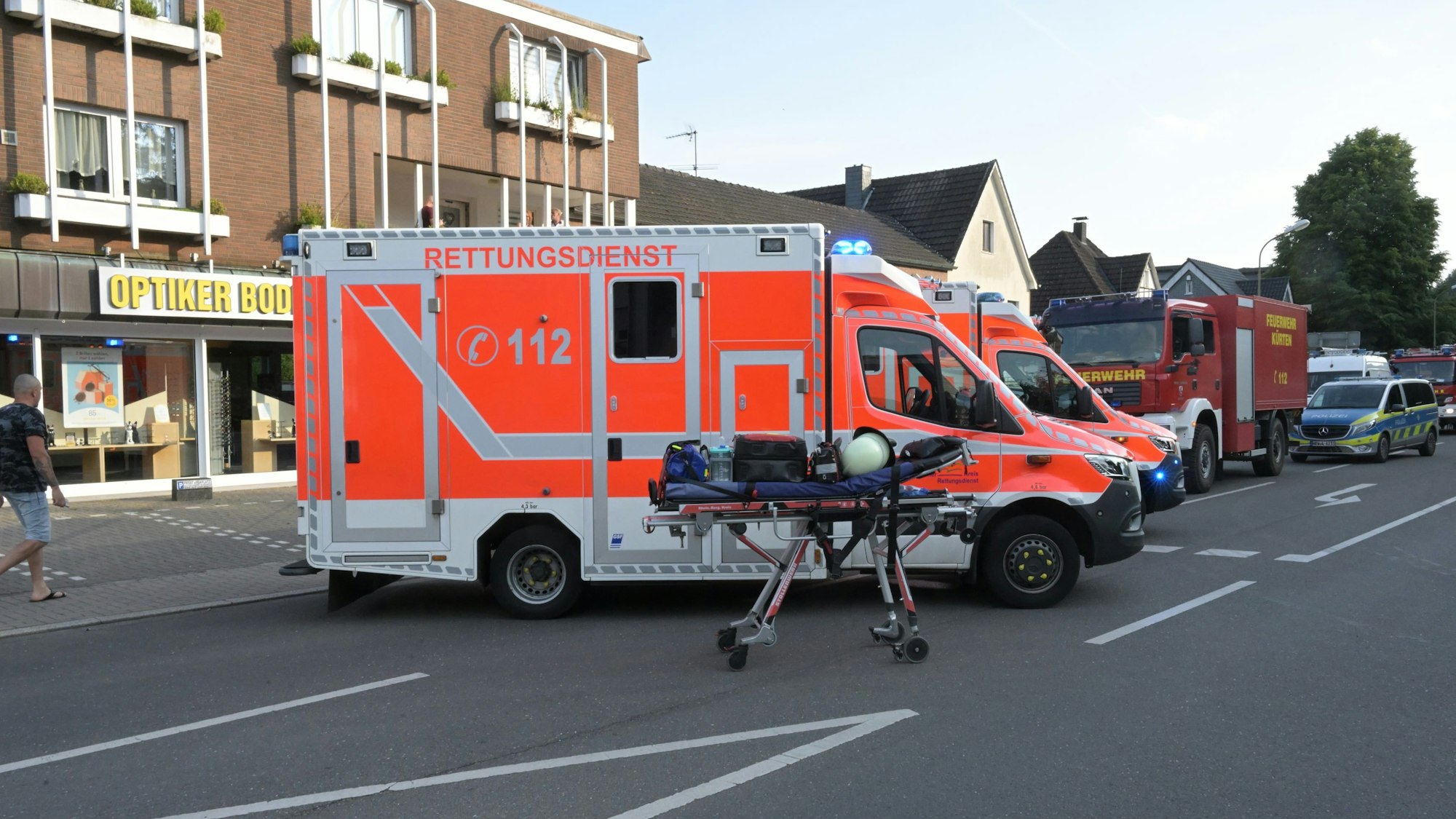 Rettungswagen und Feuerwehrfahrzeuge stehen auf der Wipperfürther Straße im gesperrten Ortskern von Kürten.