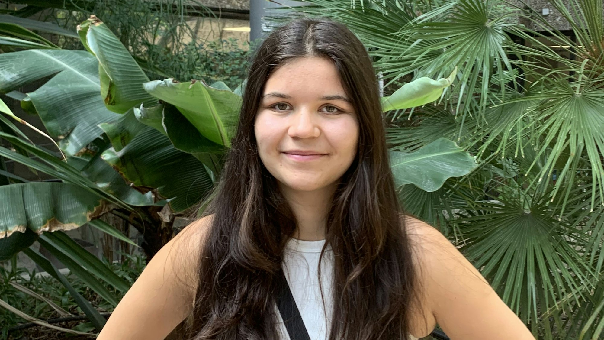 Das Porträtfoto zeigt Abiturientin Franziska Gies. Sie hat lange, dunkelbraune Haare und trägt ein weißes Top.