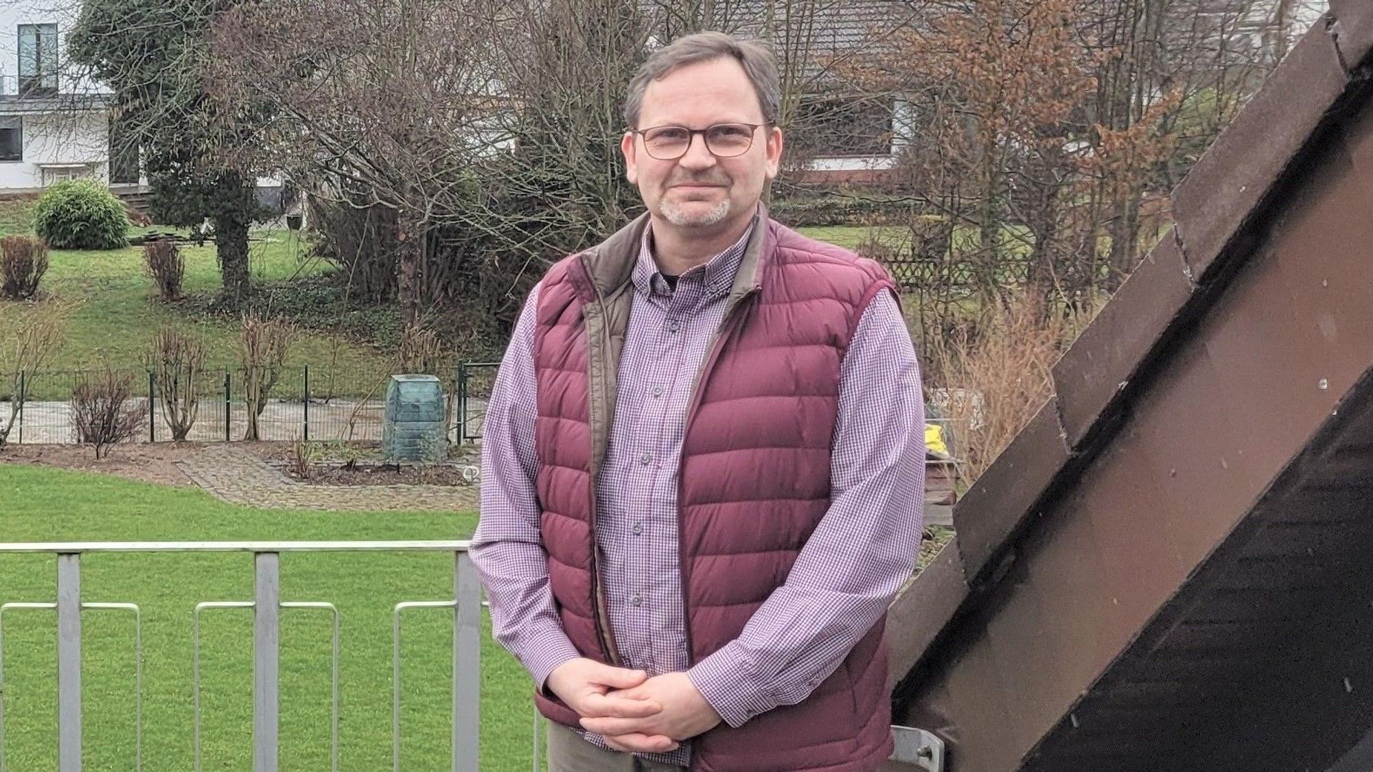 Das Bild zeigt Dr. Guido Huppertz auf einem Balkon.