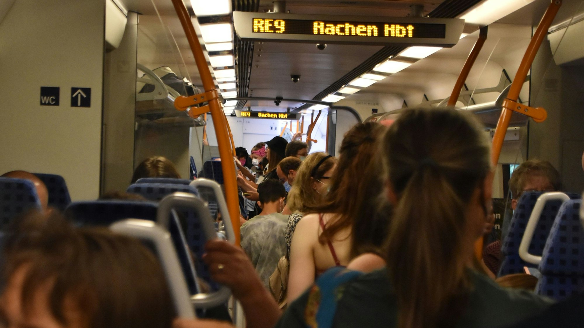 Im Waggon stehen die Menschen auf dem Gang.