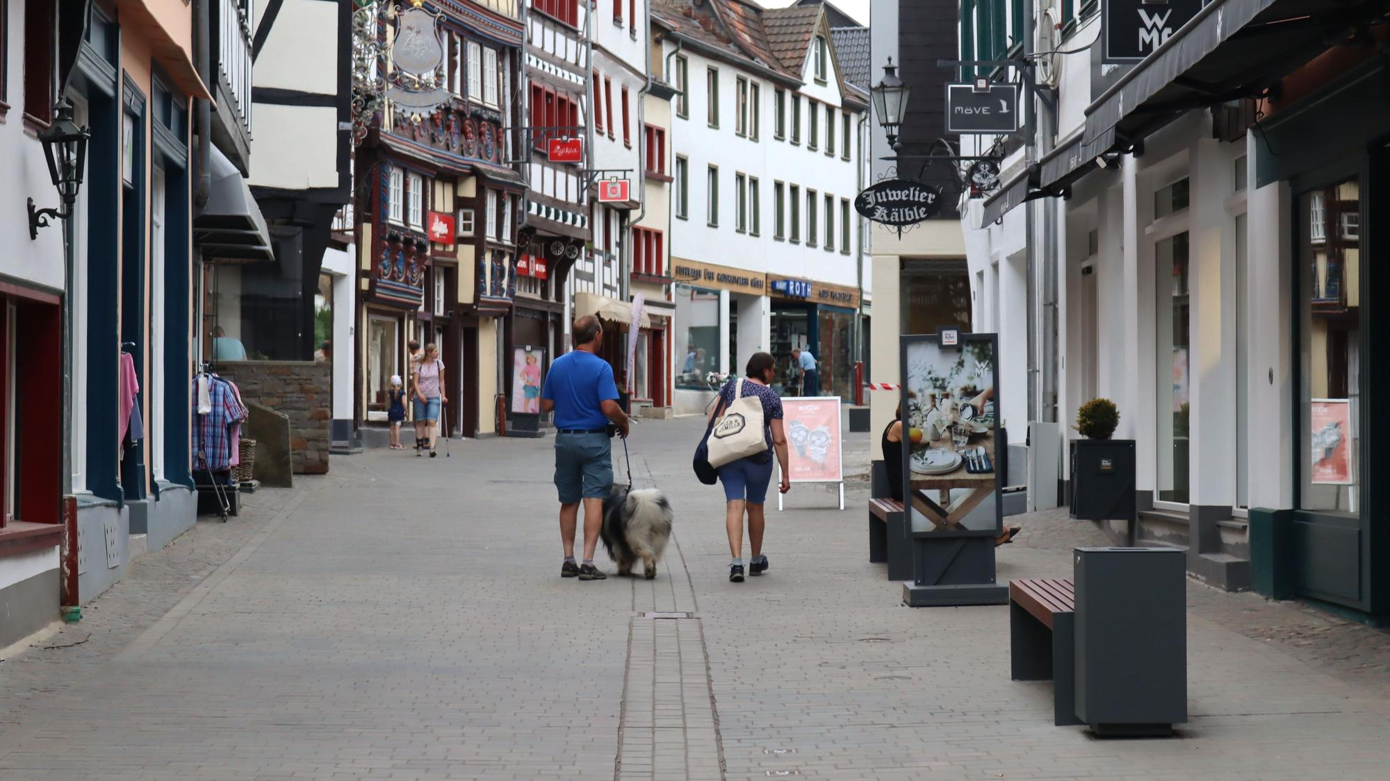 Ein Blick in die Orchheimer Straße, auf der Passanten an den Ladenlokalen entlanggehen.