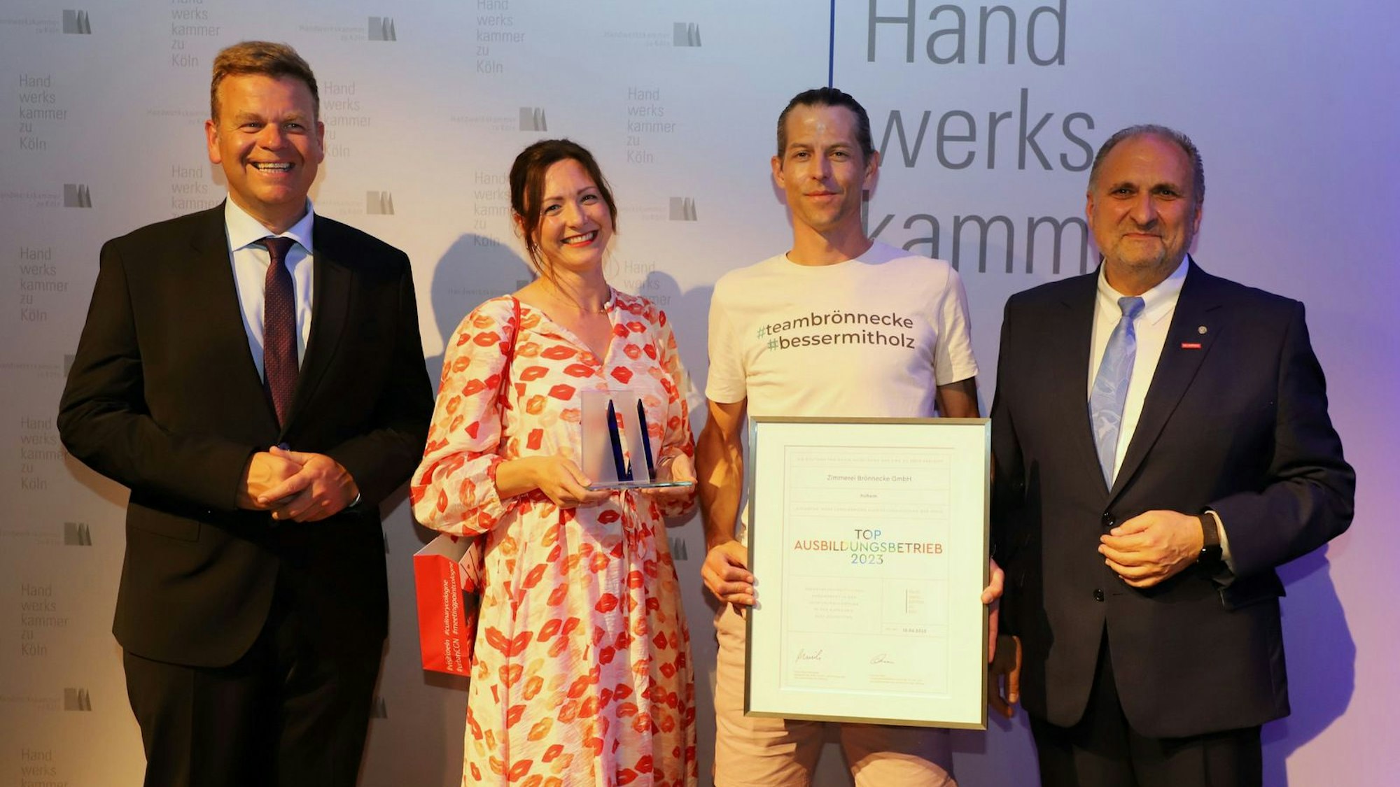 Das Foto zeigt vier Menschen bei der Handwerkskammer Köln mit einer Urkunde.