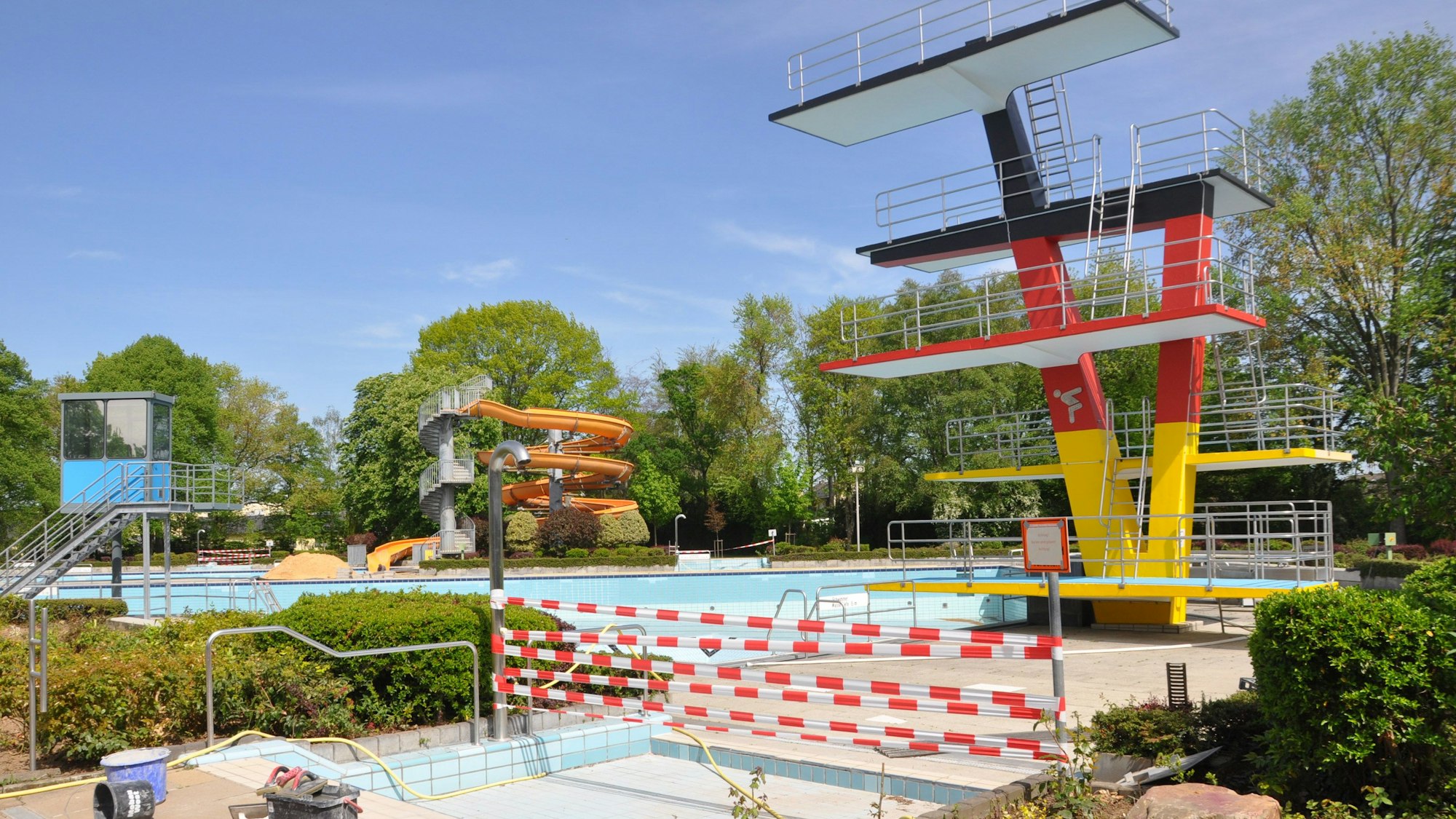 Das Bild zeigt das Elsdorfer Freibad. Der Zugang zum Becken ist mit rot-weißem Absperrband versperrt.