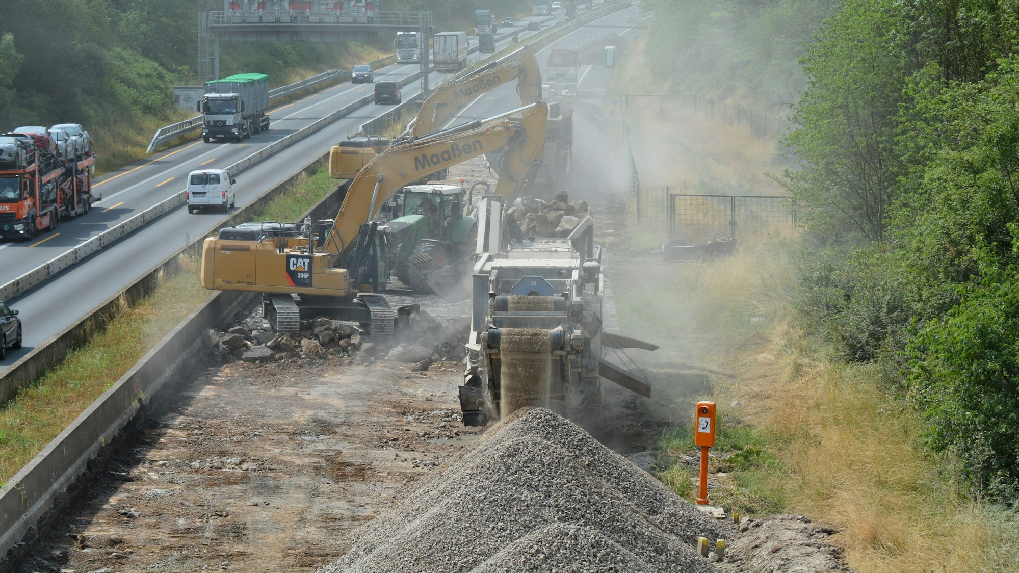 Baustellenfahrzeuge versperren die Fahrt auf der einen Richtung, der Verkehr weicht auf die andere Seite aus.