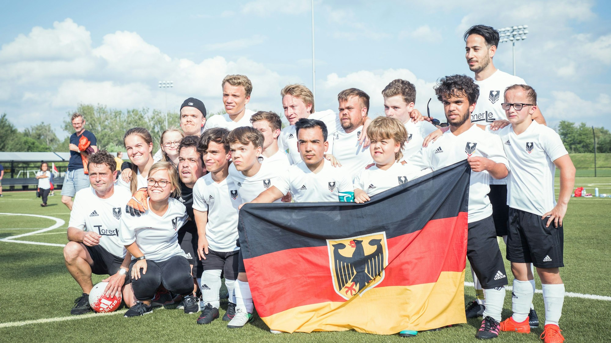 Eine Fußballmannschaft bestehend aus Kleinwüchsigen hält die deutsche Fahne hoch. Im Fußball konnte die deutsche Mannschaft bei den letzten World Dwarf Games in Kanada den Titel holen.