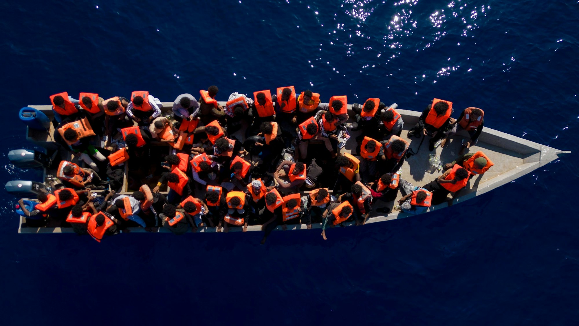 Menschen sitzen in einem Holzboot
