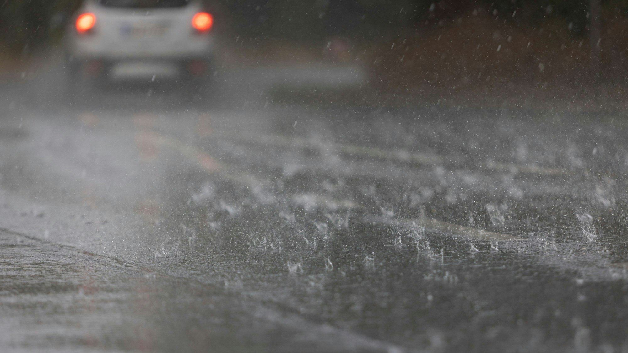 Wasser steht nach einem Regenguss durch ein Gewitter auf einer Straße. In Köln und der Region gab es am Donnerstag teils Starkregen. (Symbild)