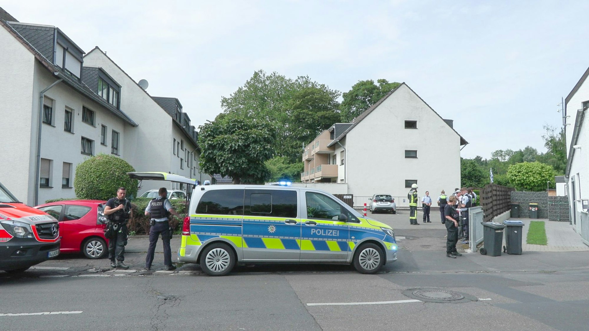Ein Polizeiwagen steht vor der Siedlung in Dellbrück, in der die Schüsse fielen.