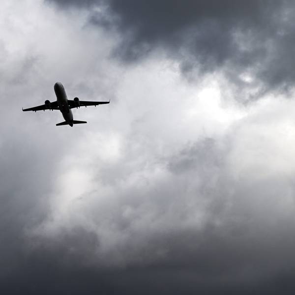 Über einem Flugzeug, das vom Flughafern Düsseldorf startet, türmen sich dunkle Wolken. (Archivbild)
