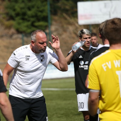 Ein Trainer gibt seinen Fußballspielern Anweisungen.