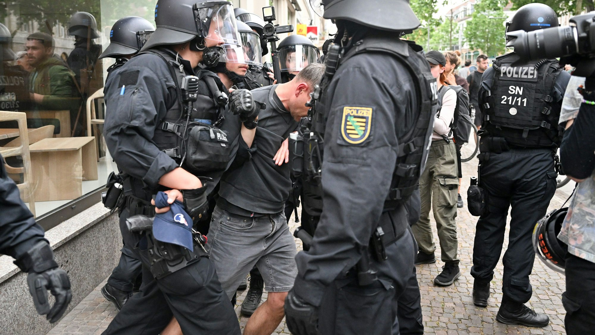 05.06.2023, Sachsen, Leipzig: Polizisten halten einen Teilnehmer aus einer Demonstration in Leipzig fest.