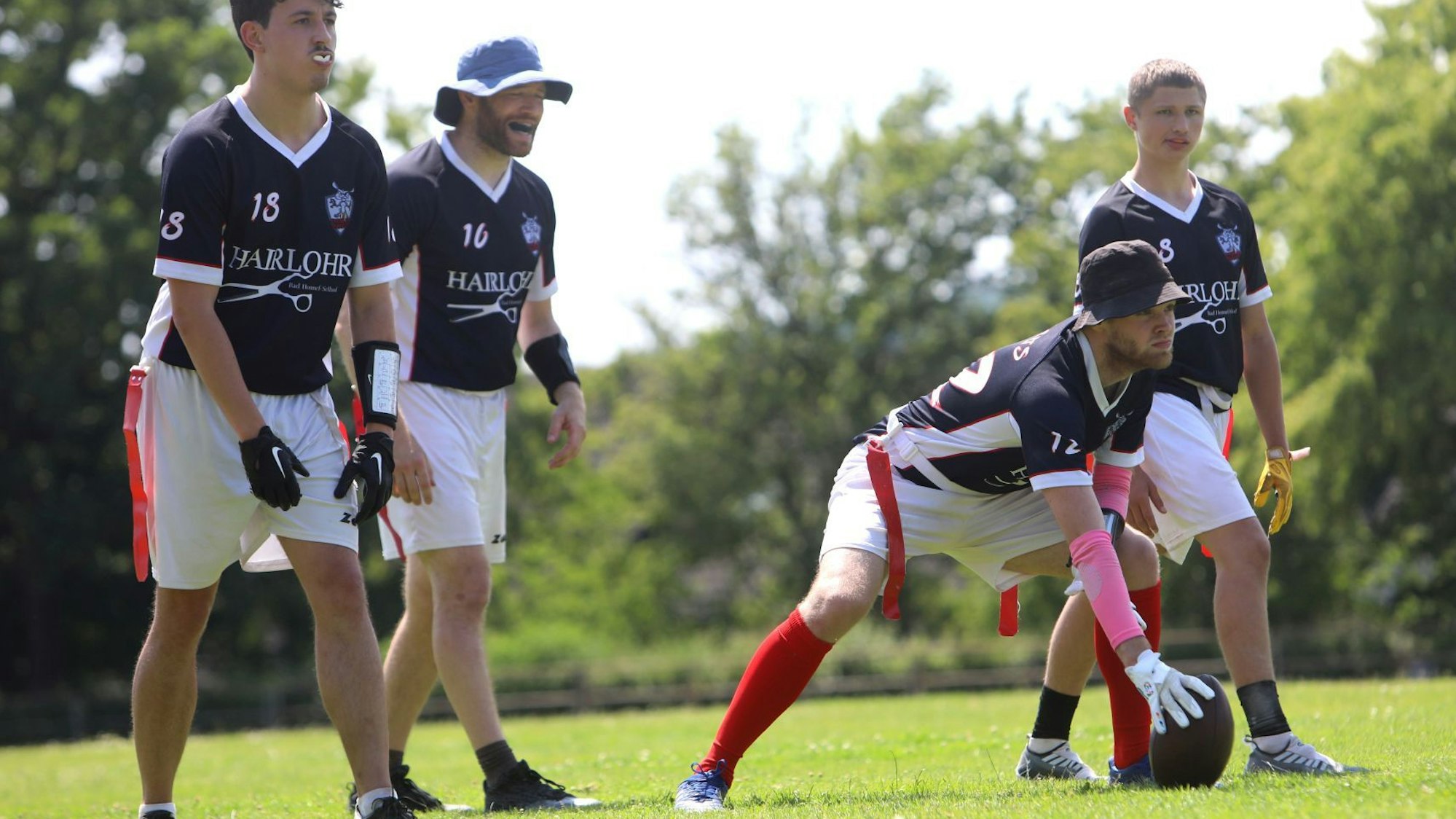 Vier Spieler der „Rheinland Rabbits“ in blauen Trikots stehen in Position, um einen Angriff zu starten.