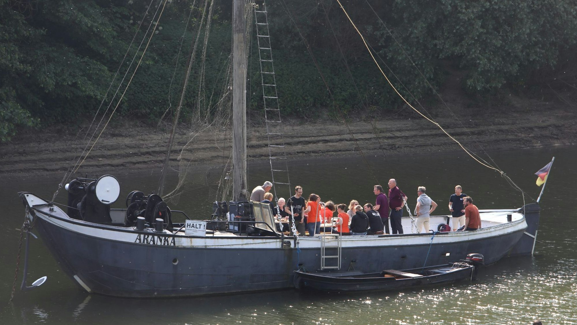 Ein historisches Flachbodenschiff liegt vor Anker.