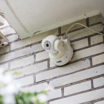 Das Bild zeigt eine an einer Hauswand installierte Kamera.