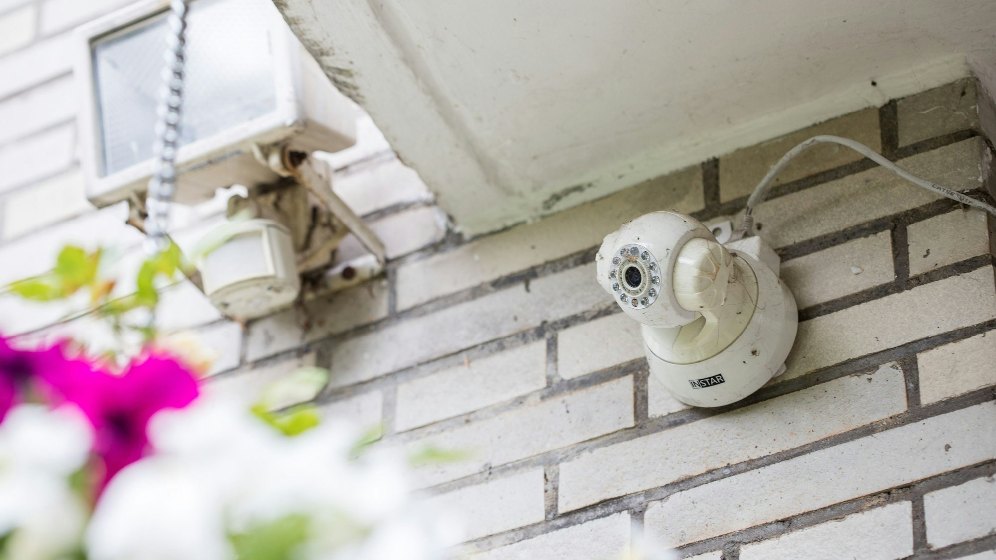 Das Bild zeigt eine an einer Hauswand installierte Kamera.