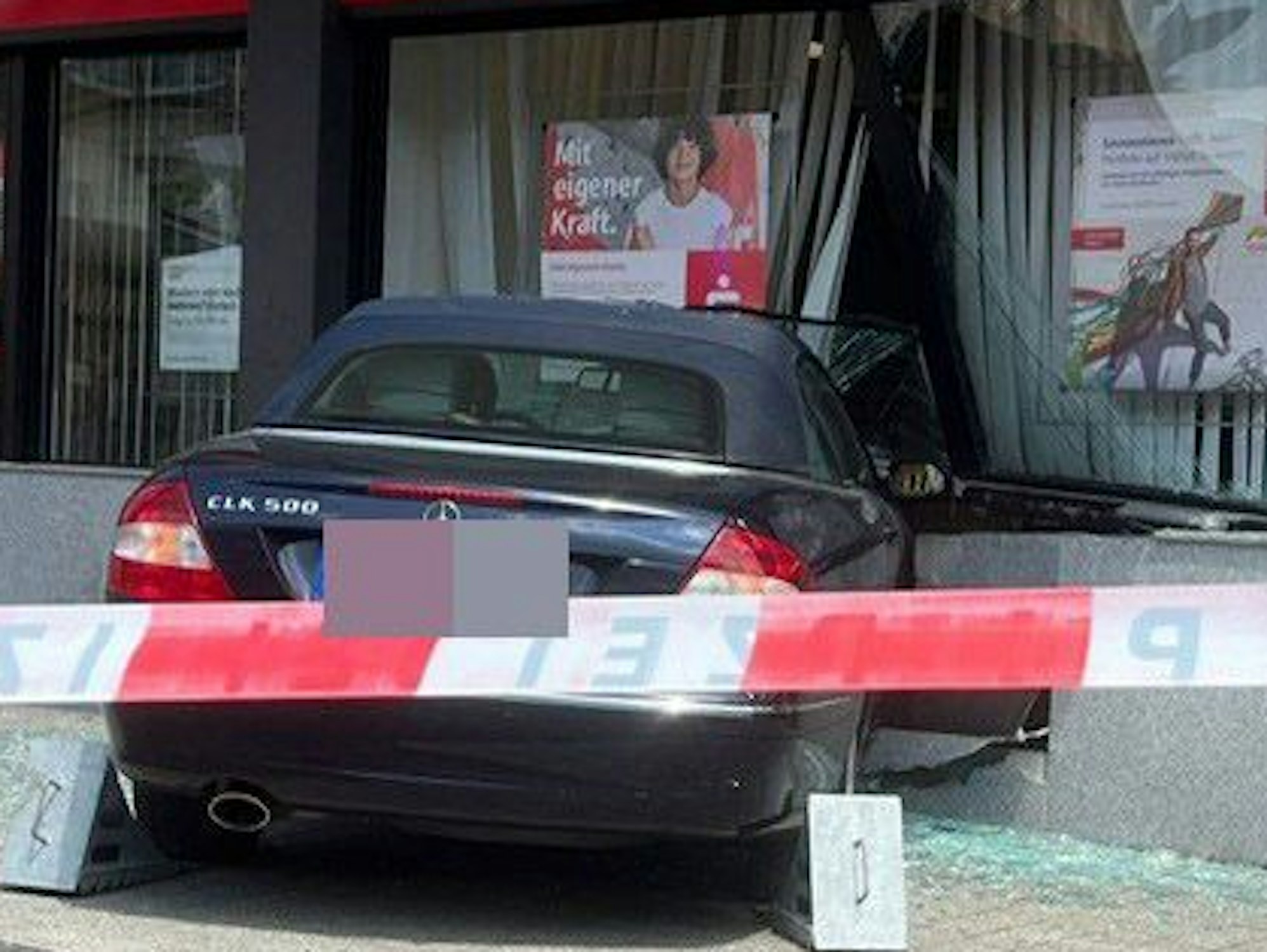 Das Bild zeigt ein Auto, das in die Bankfiliale gefahren ist.