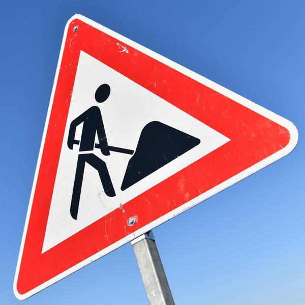 Das Foto zeigt das Verkehrszeichen „Achtung Baustelle“ vor blauem Himmel.