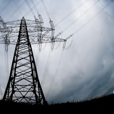 Ein Strommast steht auf einem Feld.