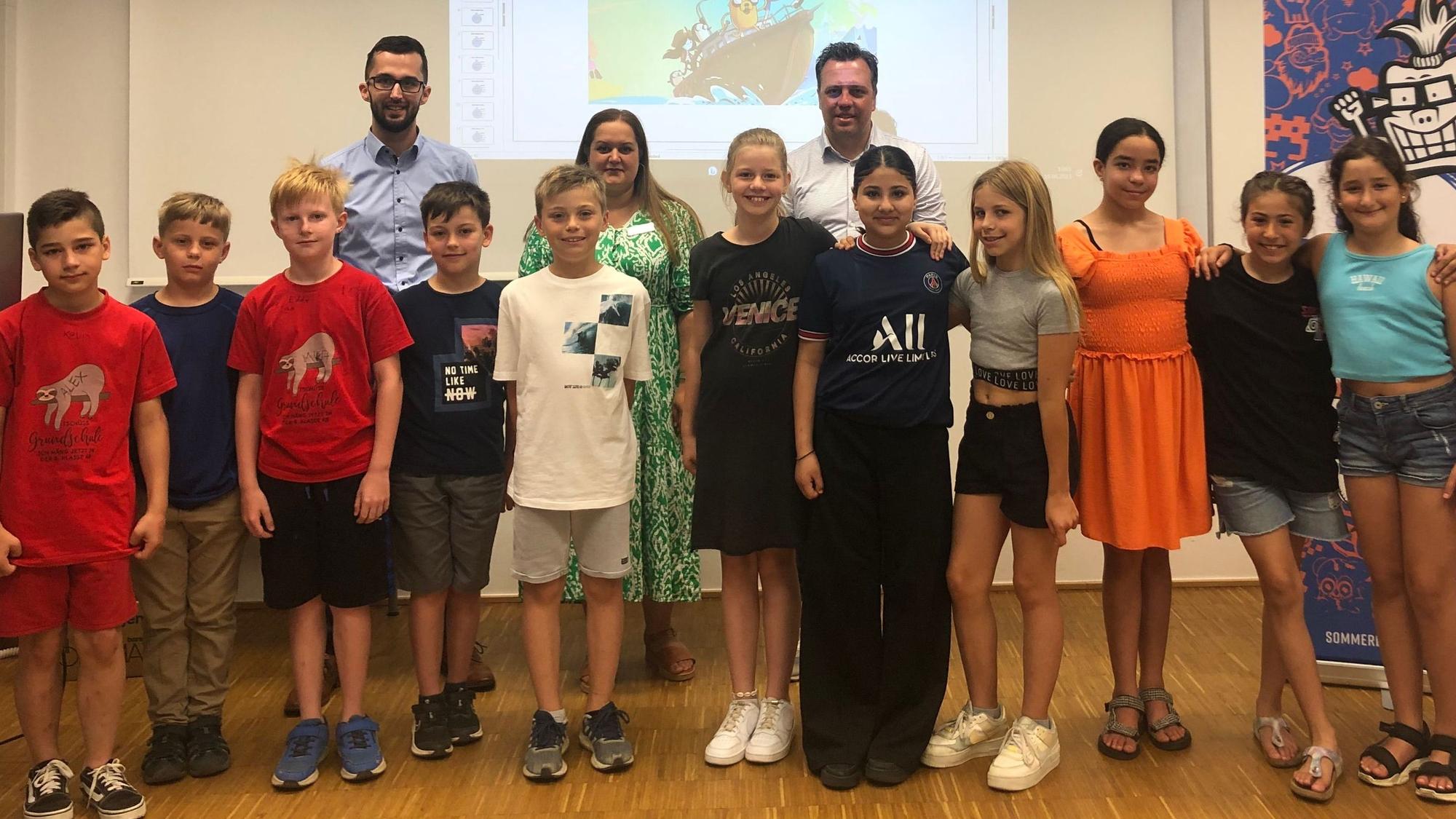 Schüler der Hermann-Josef-Grundschule posieren mit Bürgermeister Sacha Reichelt zum Auftakt des Sommerleseclubs.