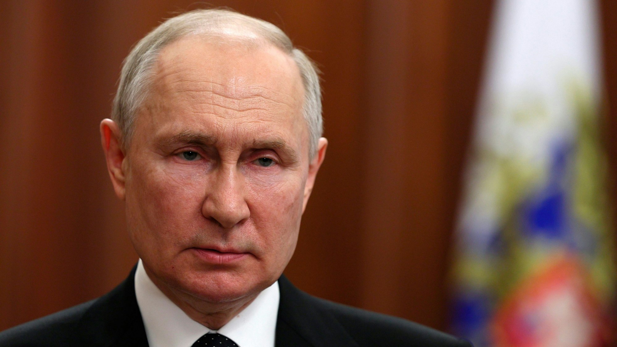 Der russische Präsident Wladimir Putin steht im Kreml vor einer russischen Flagge.