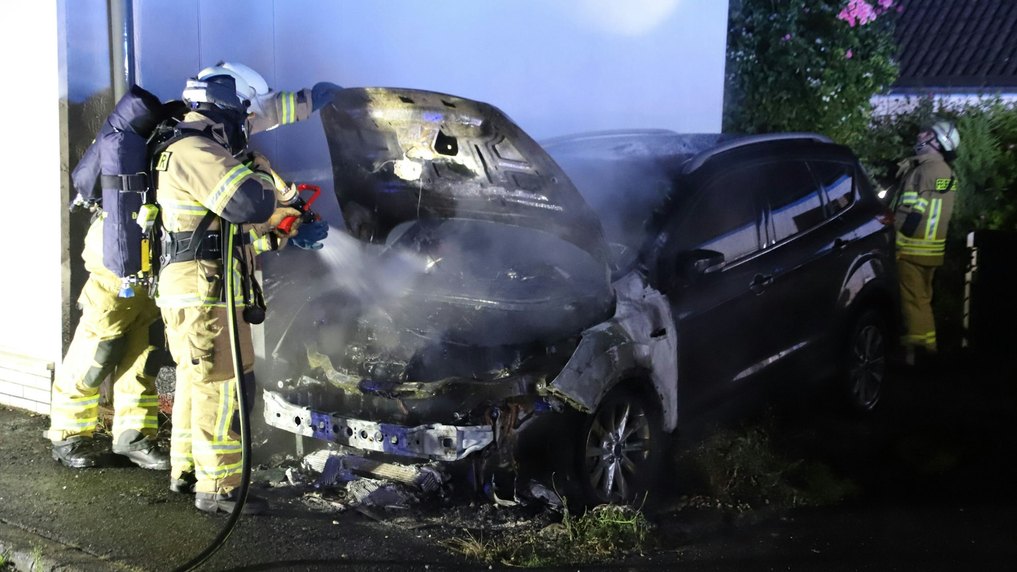 Einsatzkräfte löschen einen Pkw.
