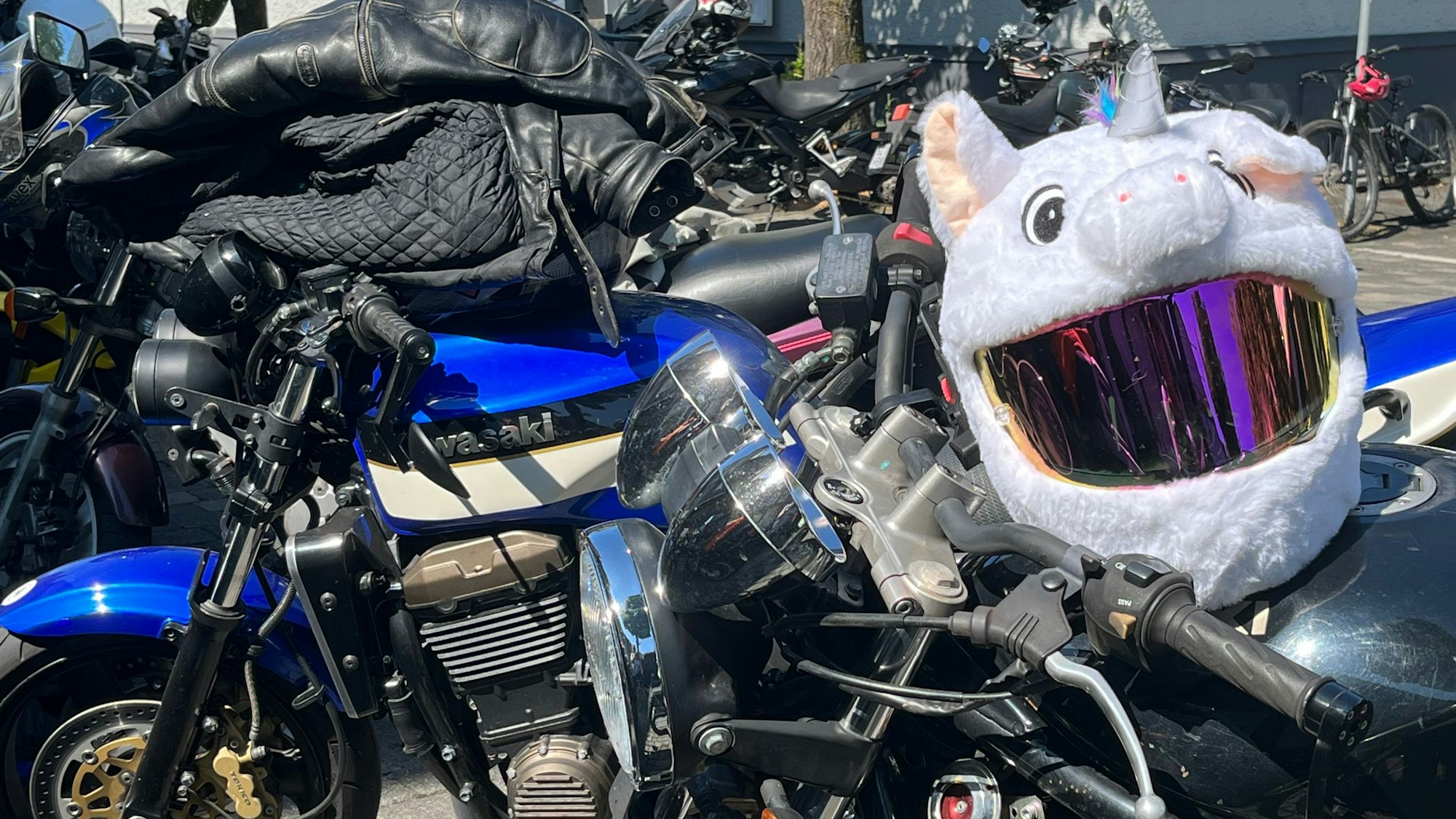 Ein Sicherheitshelm mit Pluschtier-Überzug wartet auf einem Motorrad.