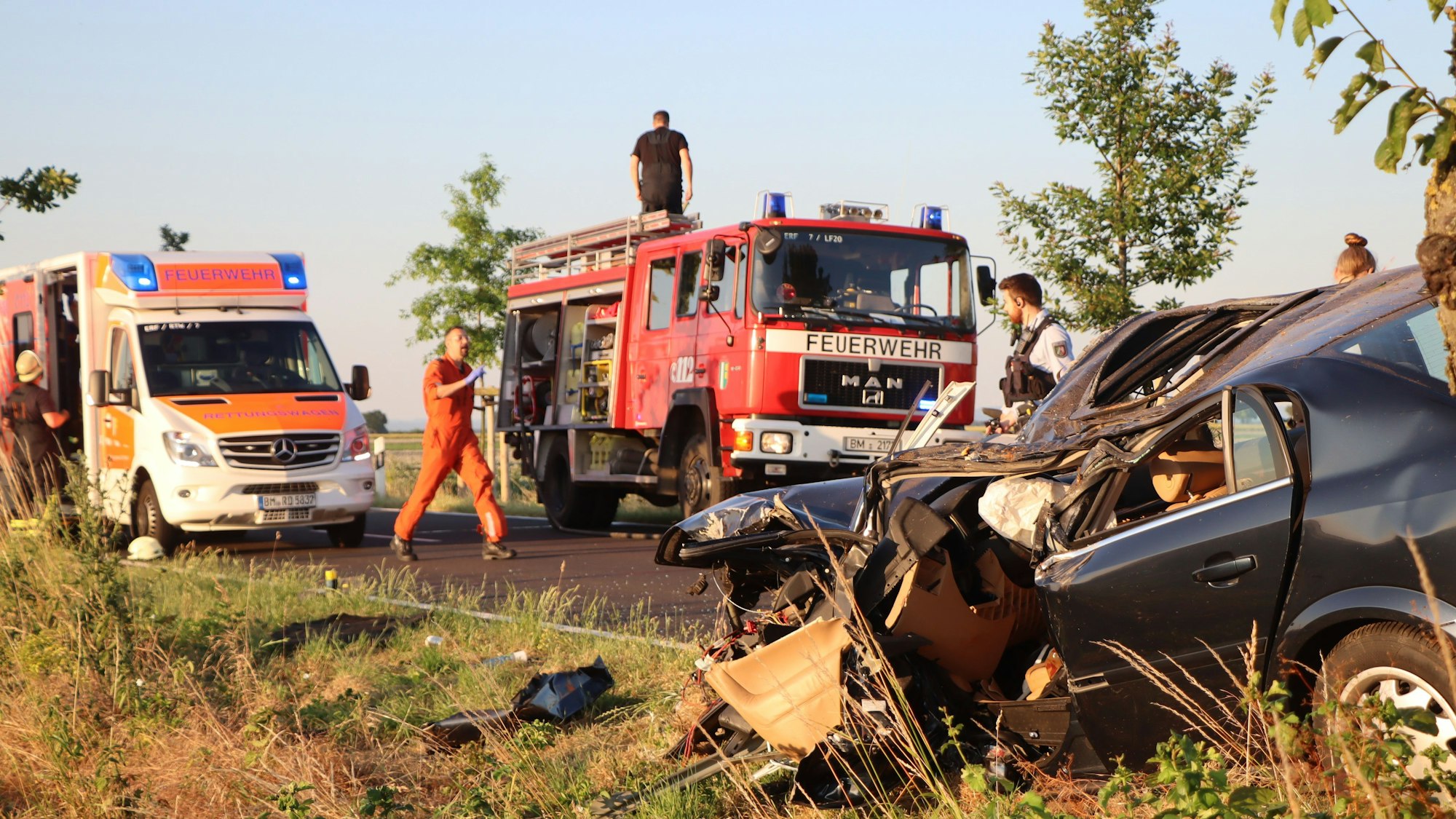 Rettungskräfte stehen an der Unfallstelle.