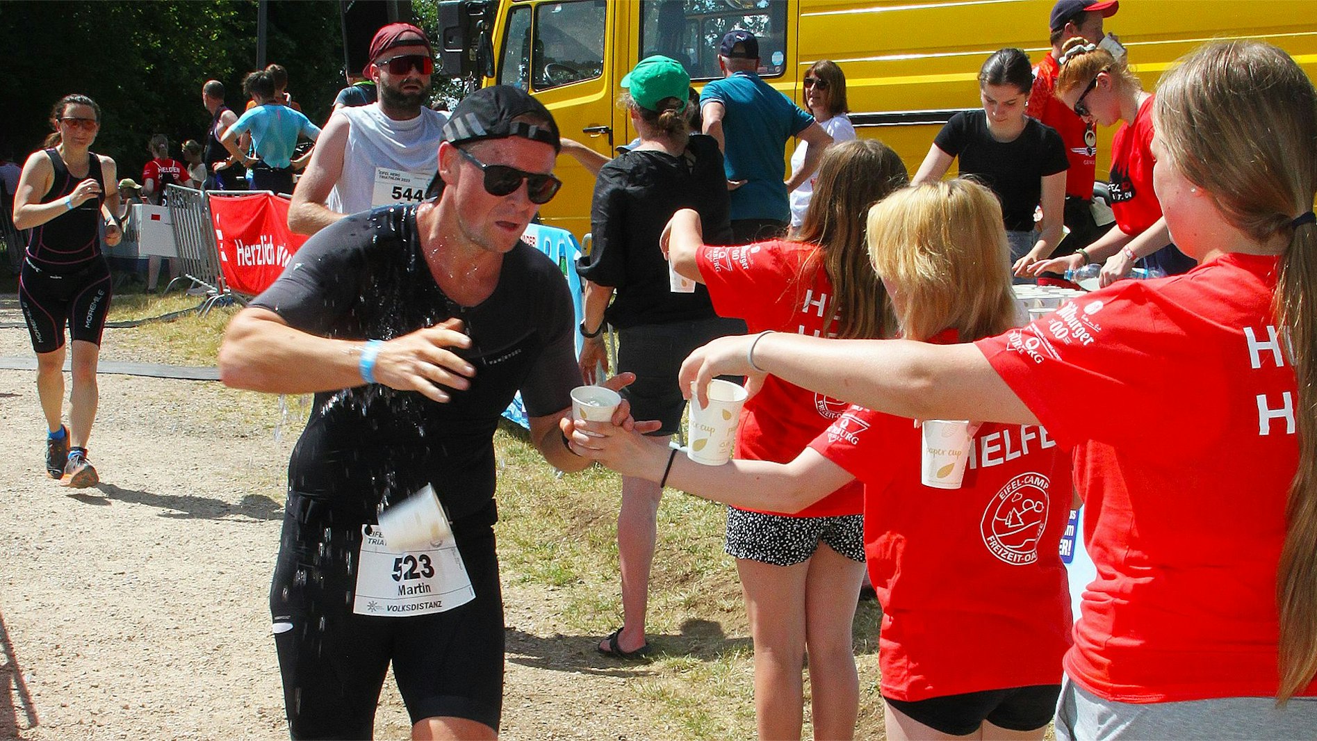 Ein Läufer nimmt an der Verpflegungsstation einen Becher Wasser entgegen.