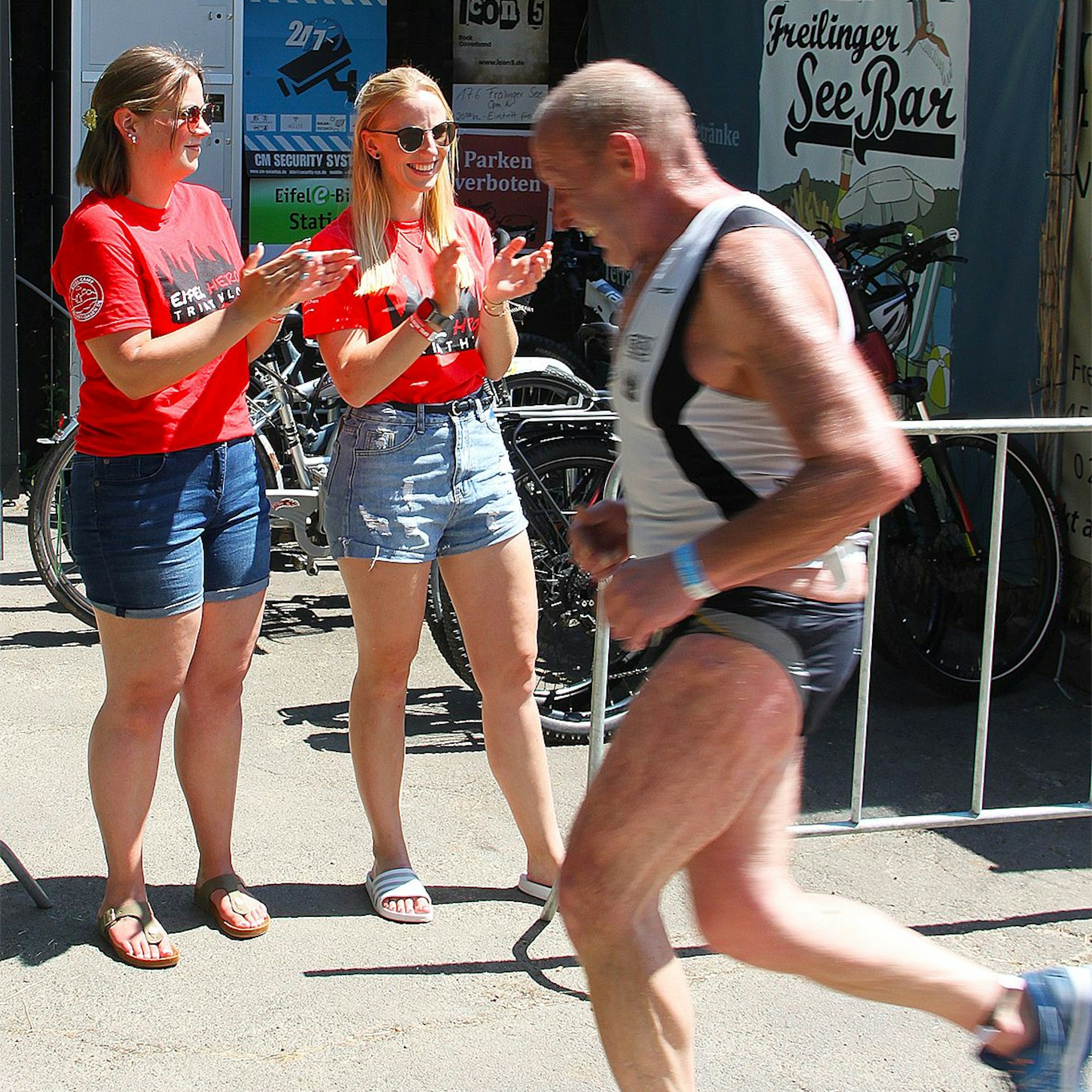 Ein Läufer passiert die beiden applaudierenden Helferinnen.