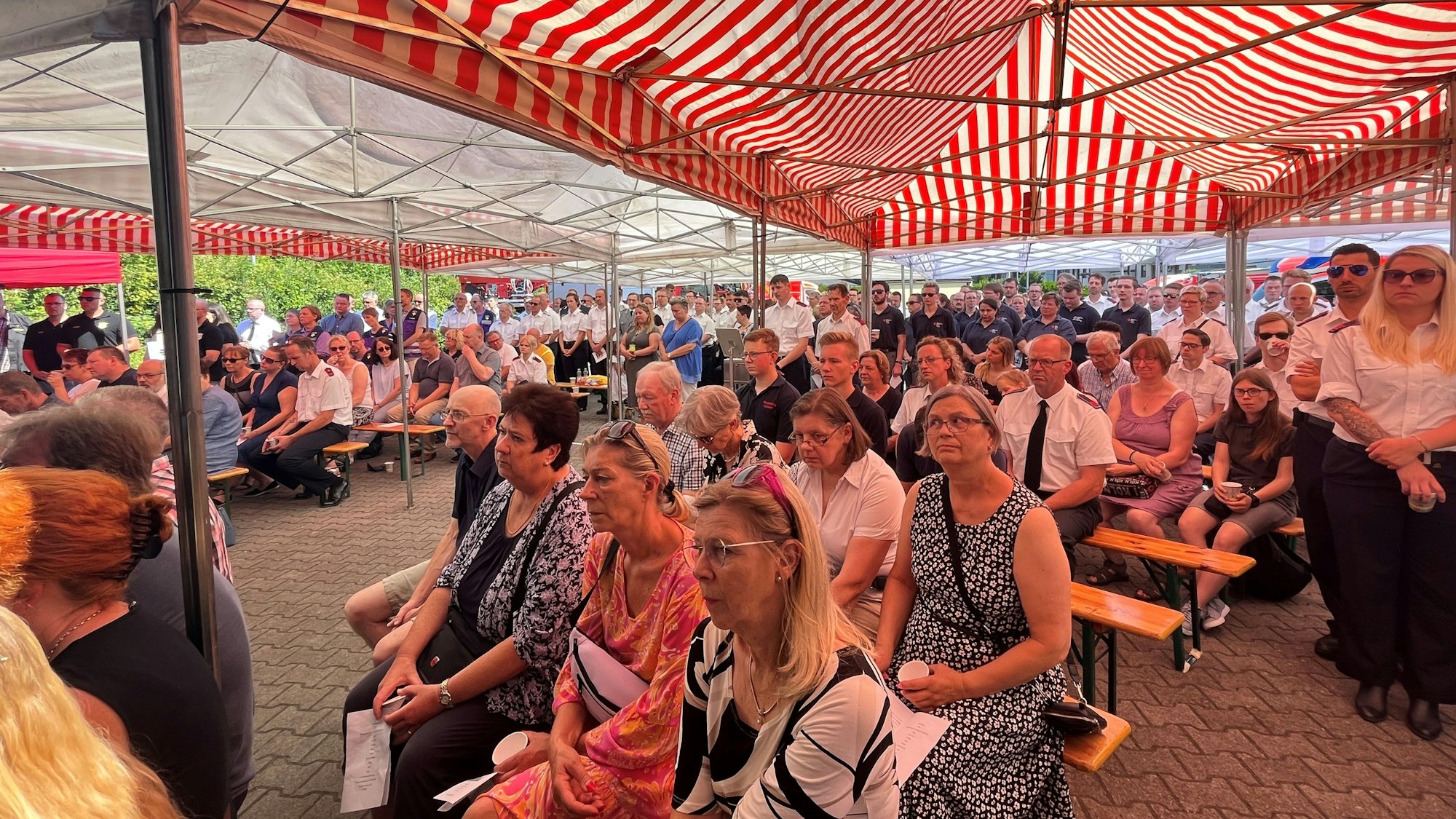 Unter einem Zeltdach verfolgen die Besucher den ökumenischen Gottesdienst in Spich.