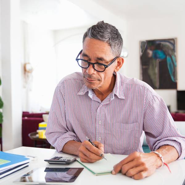 Ein Mann mit Brille arbeitet zu Hause an seinen persönlichen Finanzen.