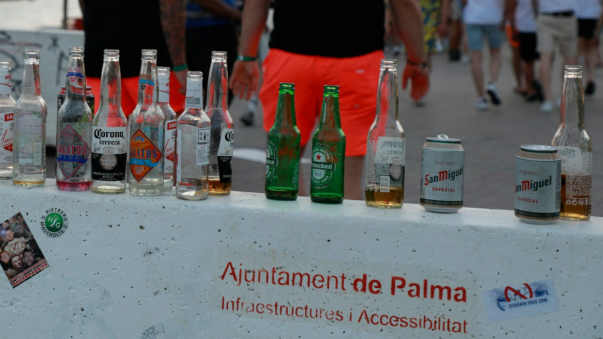 Menschen haben sich am Abend an der Promenade am Strand von Arenal versammelt. Auf einer Mauer stehen mehrere leere Flachen alkoholischer Getränke. Auf der Urlaubsinsel Mallorca gibt es immer wieder Klagen über Betrunkene, die grölend herumtorkeln, in Ecken pinkeln, sich übergeben oder ihre Notdurft öffentlich erledigen.