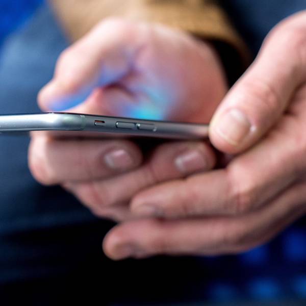 Mann hält Smartphone in den Händen.