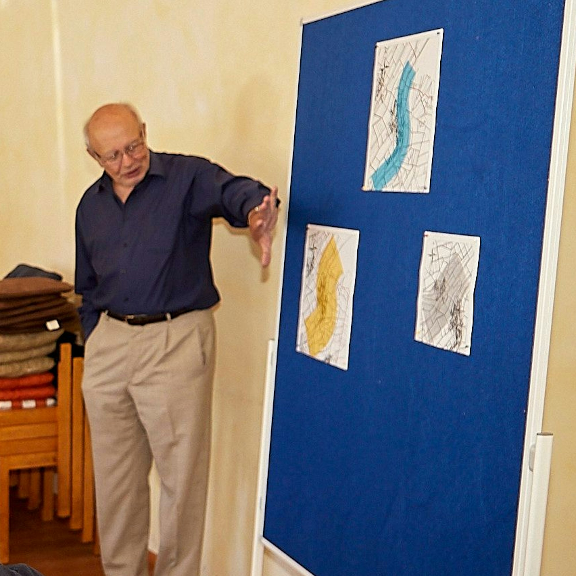 Schevener Ortsvorsteher Hans Reiff an einer Tafel mit Karten.