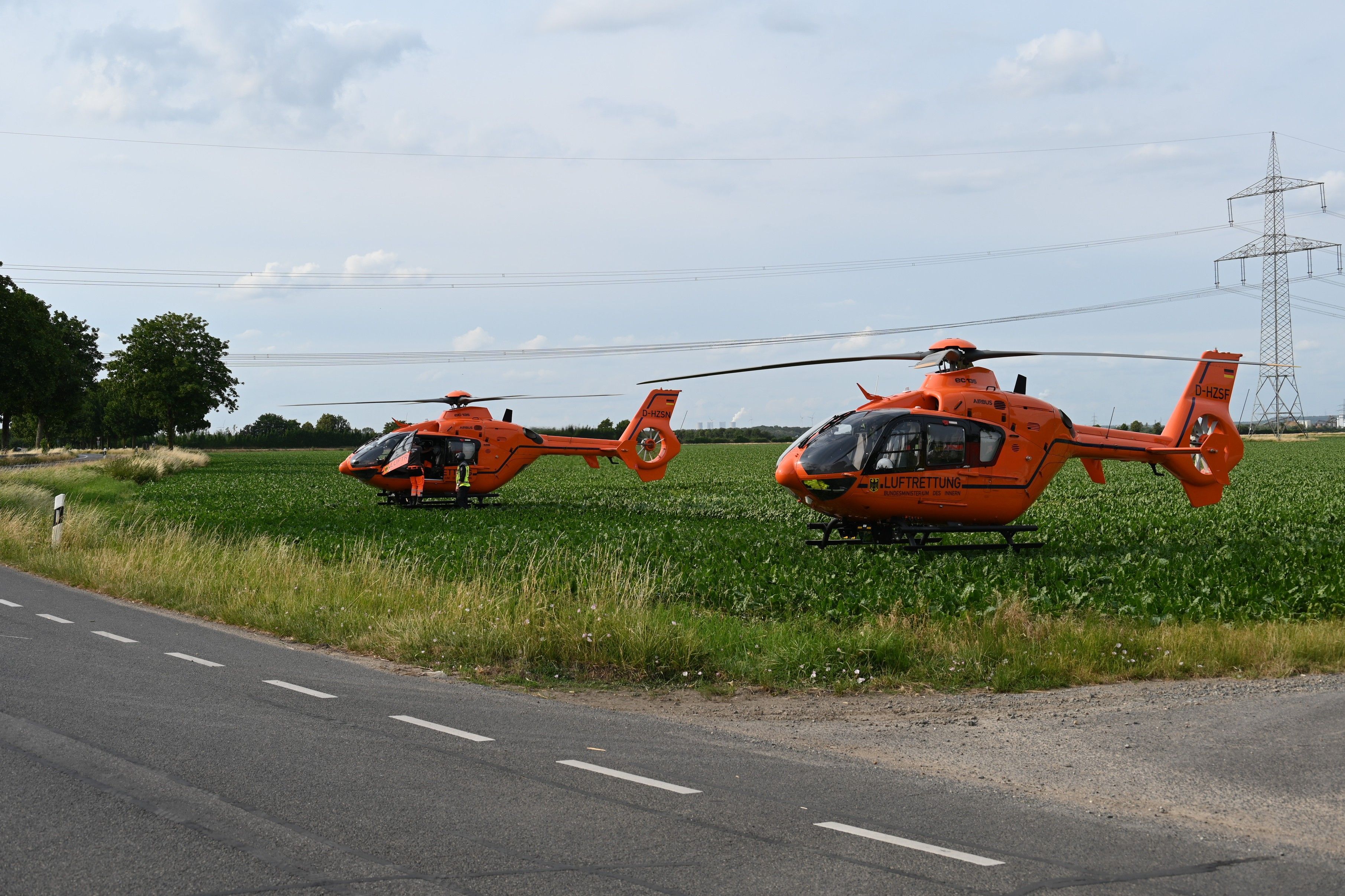 Das Bild zeigt einen Rettungshubschrauber auf einem Feld.