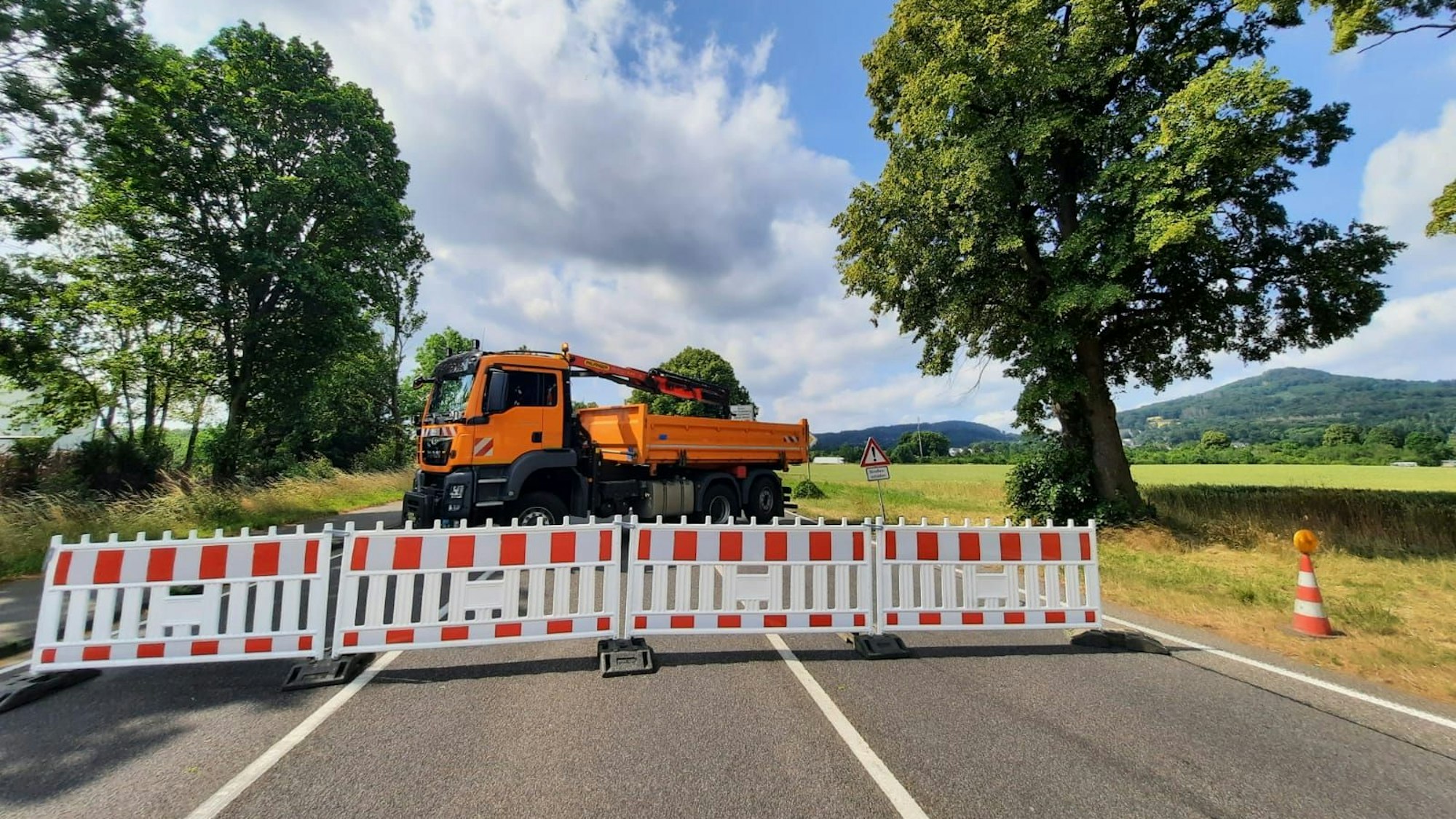 Baken und ein Lkw versperren die Landesstraße 331. Rechts und links stehen Bäume am Fahrbahnrand.