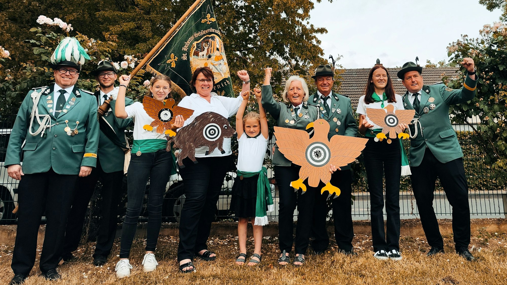 Die jubelnden Sieger der Schießwettbewerbe mit der neuen Schützenkönigin, die den hölzernen Königsvogel hält.